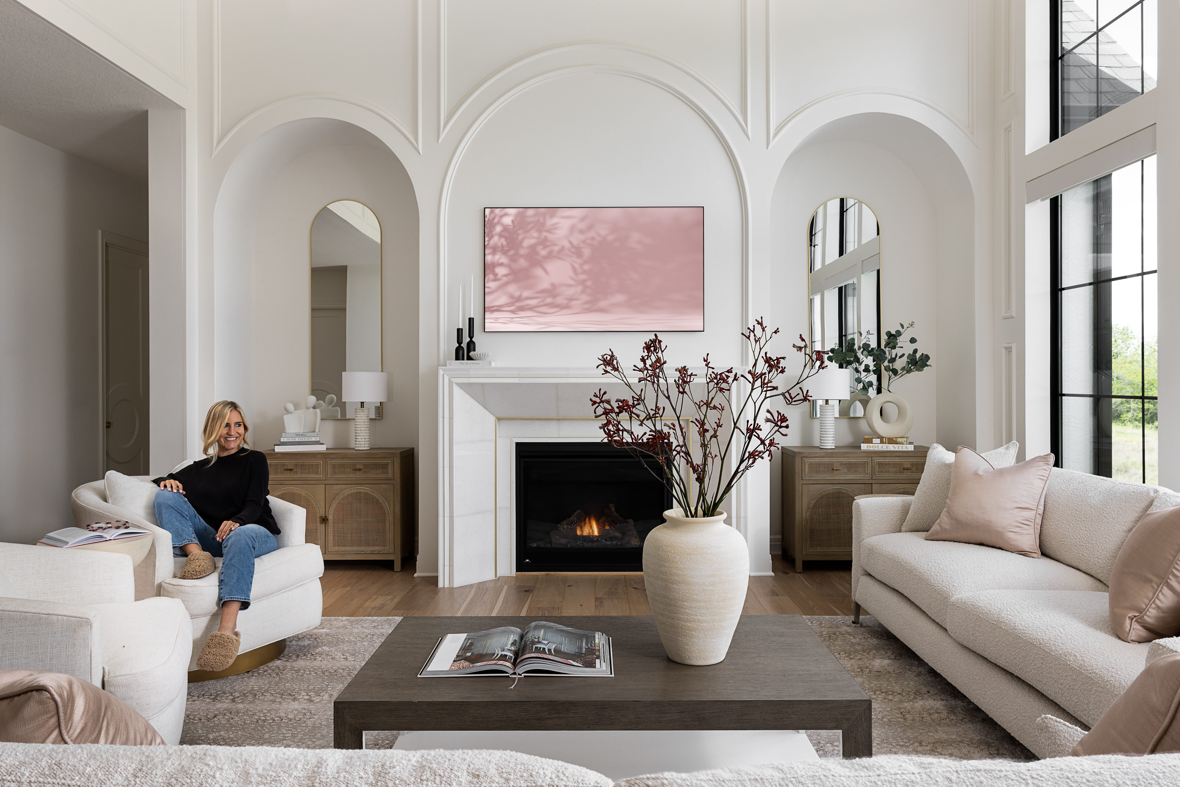 Luxury residential living room featuring custom upholstered seating, arched architectural details, stone fireplace, and refined Midwest interior design.