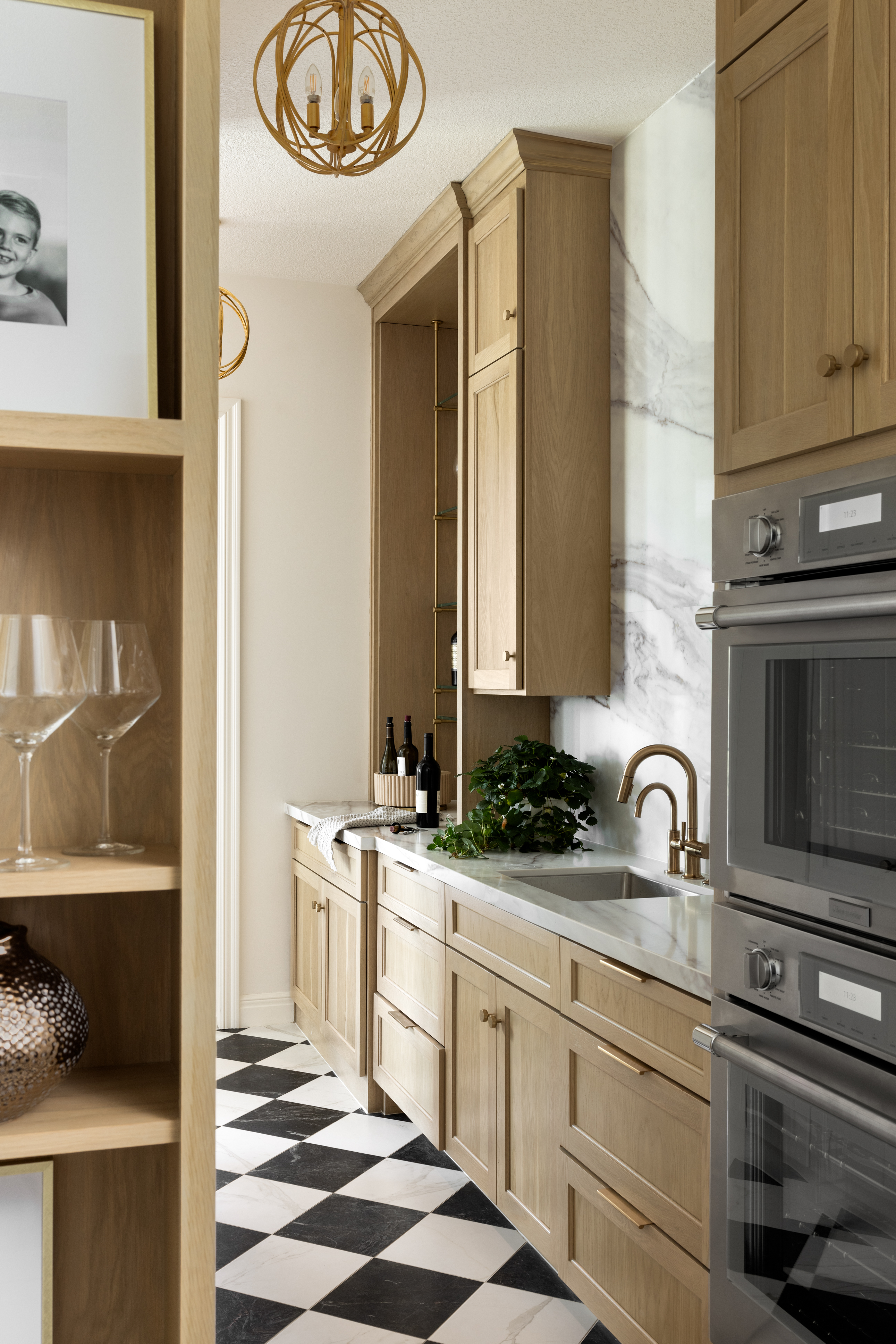 Luxury kitchen interior featuring custom wood cabinetry, marble backsplash, built-in appliances, and refined Midwest interior design.