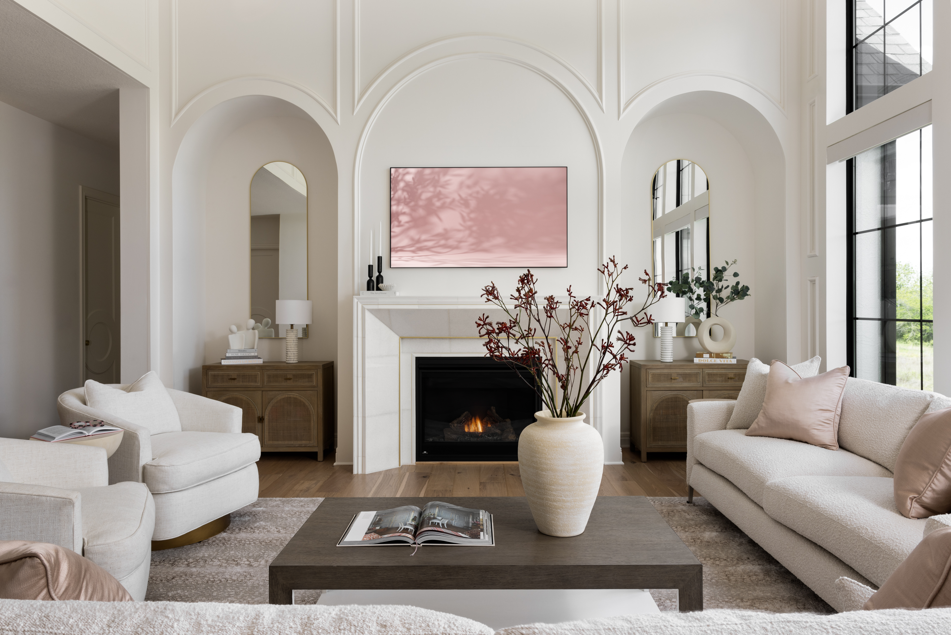 Luxury residential living room featuring custom upholstered seating, arched architectural details, stone fireplace, and refined Midwest interior design.